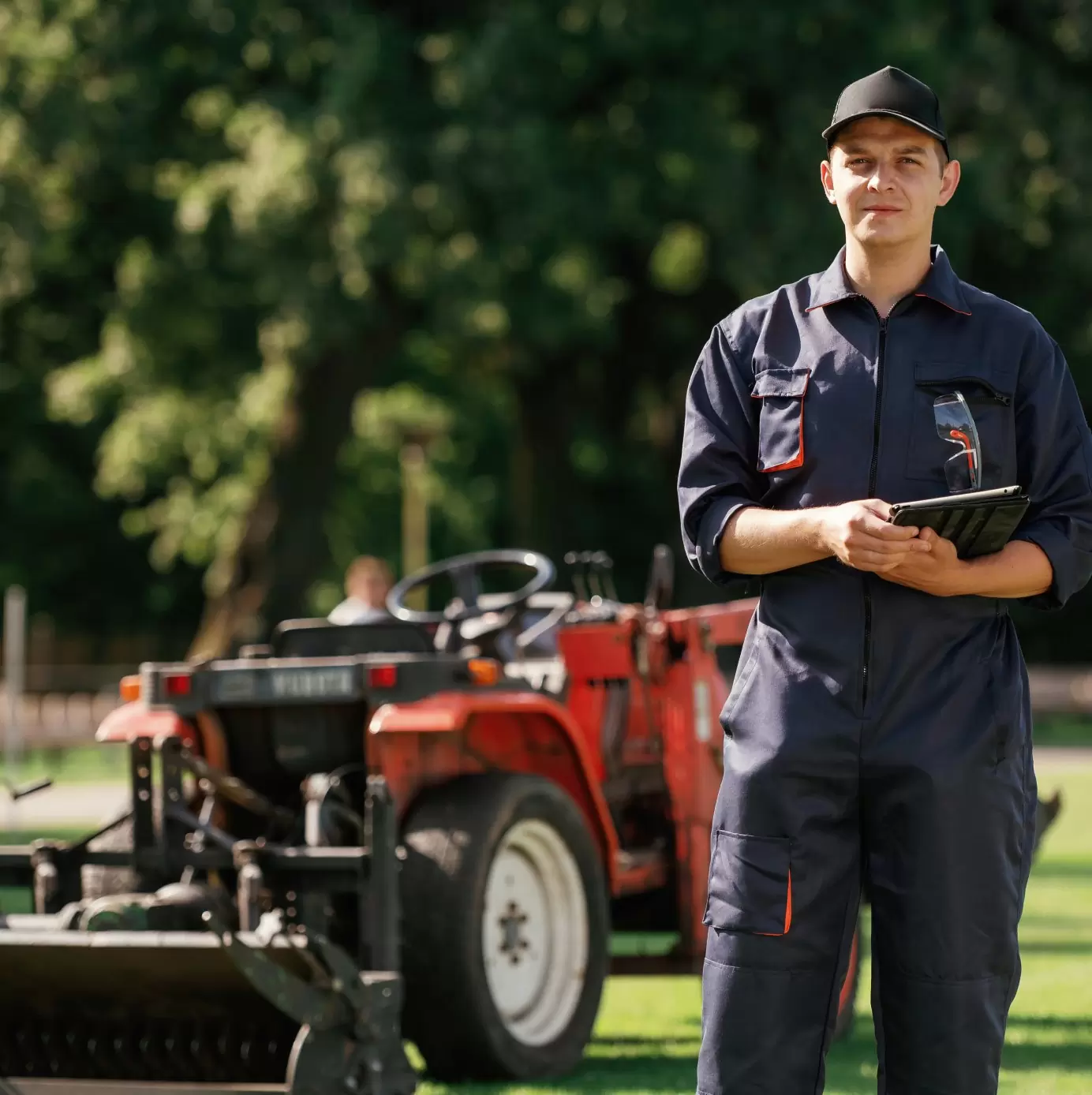 man-is-with-utility-tractor-with-grass-cutter-aerator-equipment-field
